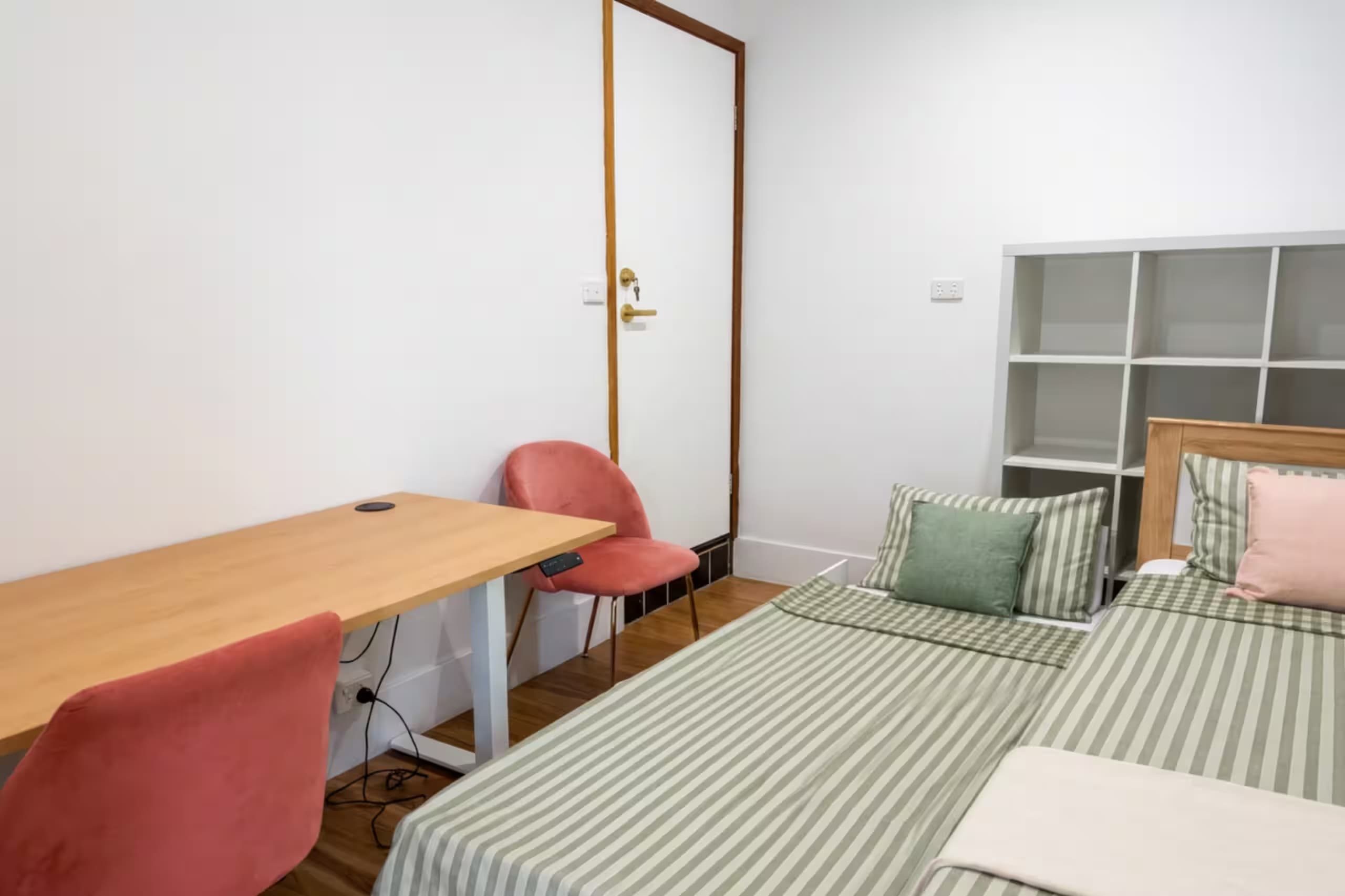 Flexible office space with an electric sit-stand desk that doubles as extra sleeping quarters with a trundle bed
